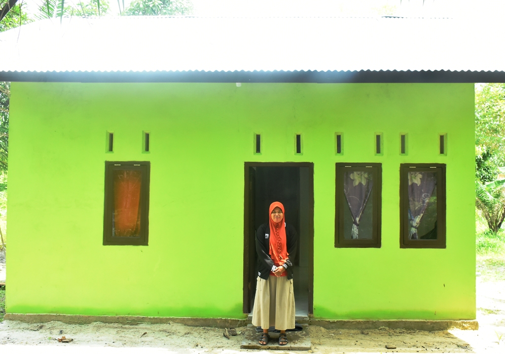 Endah saat berfoto di depan rumah barunya