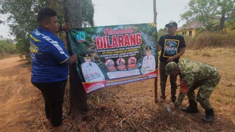 Babinsa Desa Lengang dan Perangkat Desa Pasang Spanduk Imbauan untuk Cegah Karhutla
